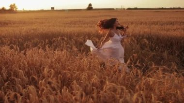 Tarlada dans eden güzel, neşeli kadın.