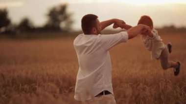 Mutlu baba çocuğu çayırda büküyor..