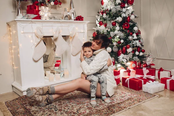 Mutlu ebeveynler Noel süslemelerini ağaçta gösteriyorlar küçük oğlu için..