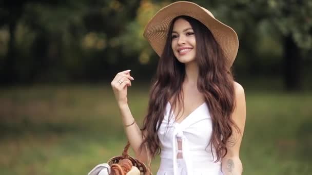 Красивая леди в соломенной шляпе, бродит по парку — стоковое видео