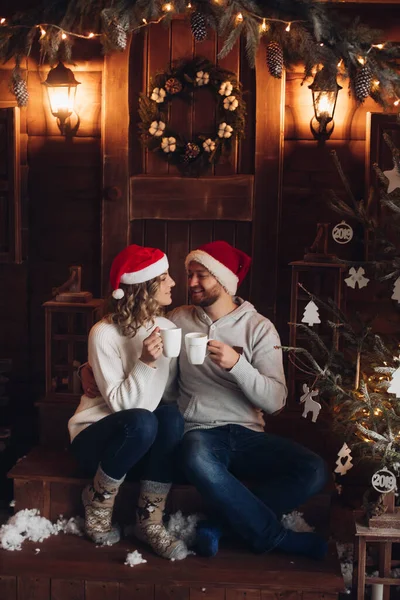 Bild von zwei schönen kaukasischen Liebhabern in denselben Pullovern, Hosen und Socken lächelt im Fotostudio vor Weihnachten — Stockfoto