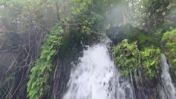 Muž sedět pod vodopádem v přírodě výstřel