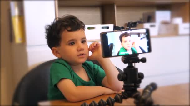 用智能手机在迷你脚架上录制Vlog的小男孩 — 图库视频影像