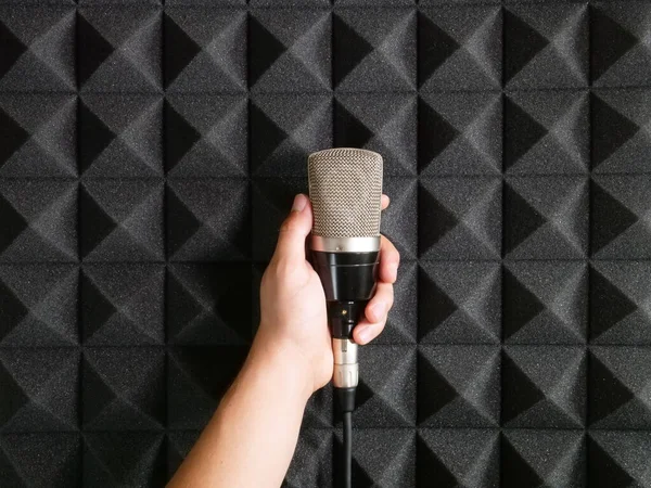 Mão Segurando Microfone Contra Espuma Acústica Profissional — Fotografia de Stock