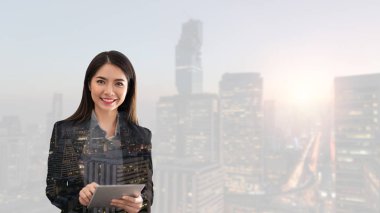 Asya işkadını güzel gülümseme ve tablet Bangkok City üzerinde çalışıyor. Teknoloji ve iş kavramı