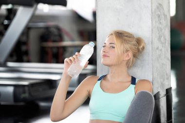 Mutlu bir gülümseme ve içme suyu spor salonunda egzersiz dışarı işten sonra beyaz genç kadınlar. Yaşam sağlıklı yaşam kavramı.