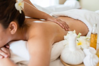 Genç ve güzel Asyalı bir kadın salondaki masaj salonunda uyur ve dinlenir. Masözün odak elini seç