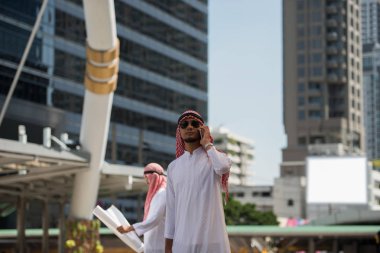 Arap Müslüman mühendis kullanım telefonu musun danışmanları işçi için arka plan City, iş bölgesinin yüksek kamaştırmak bina ile bir inşaat