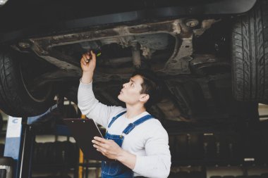 Asya genç adam tamirci Pano denetim listesi araba servis merkezi holding. İniş takımı tamiri.