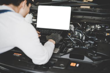 Bir bilgisayarda çalışan genç erkekler mekanik bir araba motoru bağlı. Mockup bilgisayar