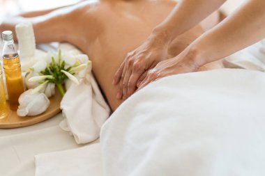 Genç ve güzel Asyalı bir kadın salondaki masaj salonunda uyur ve dinlenir. Masözün odak elini seç