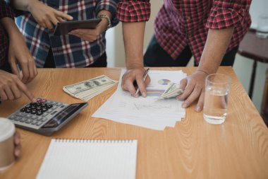 Grup işadamı ve kadın hesap makinesi kullanıyor. İş payını hesaplamış.