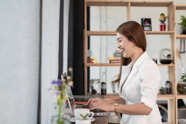 Bir Asya işadamı gülümseyen mutlu çalışma ile bir laptop bir kafede Cafe güzel genç kadın.