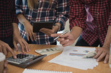 Grup işadamı ve kadın hesap makinesi kullanıyor. İş payını hesaplamış.