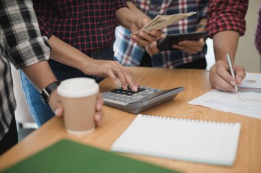 Grup işadamı ve kadın hesap makinesi kullanıyor. İş payını hesaplamış.