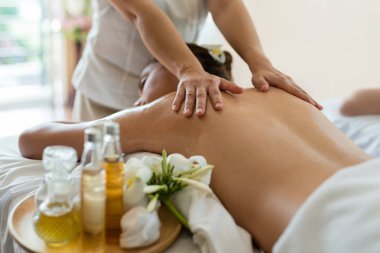 Genç ve güzel Asyalı bir kadın salondaki masaj salonunda uyur ve dinlenir. Masözün odak elini seç