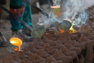 Eriyen metaller kalıba dökülüyor. Buda resimleri oluşturma adımları.