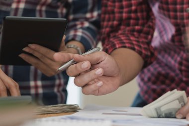 Grup işadamı ve kadın hesap makinesi kullanıyor. İş payını hesaplamış.