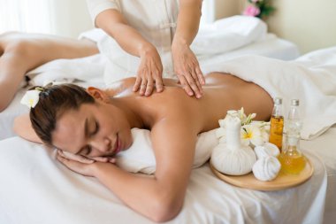 Genç ve güzel Asyalı bir kadın salondaki masaj salonunda uyur ve dinlenir. Masözün odak elini seç