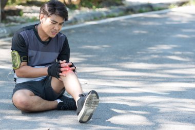 Asya 'lı genç koşucunun iltihaplanması ve şişkinliği ağrıyan dizine, sağlıklı yaşam tarzına ve erkekler dizlerine dokunup acı hissetmelerine neden olur. Spor yaparken yaralanma konsepti.
