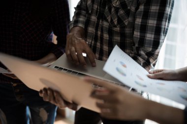 Ekose gömlekli bir kadın ve erkek çalışan bir grup insan çalışmak ve konuşmak için senin bilgisayarını kullanıyor. takım çalışması işi