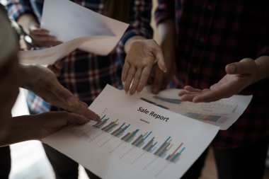 Ekose gömlekli bir kadın ve erkek çalışan bir grup insan iş yapma hakkında konuşuyor / danışmanlık yapıyor. Takım çalışması iş toplantısı