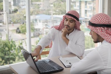 İki iş adamı bir dizüstü bilgisayarla çalışıyor. İş analizi yapıyorlar, tartışıyorlar. Beyin fırtınası, takım çalışması, toplantı konsepti.