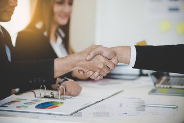 Asyalı iş adamları başarılı bir iş toplantısından sonra tokalaşıyor. hedefler, iş anlaşmaları kavramı