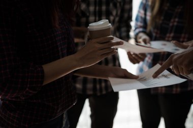 Ekose gömlekli bir kadın ve erkek çalışan bir grup insan iş yapma hakkında konuşuyor / danışmanlık yapıyor. Takım çalışması iş toplantısı