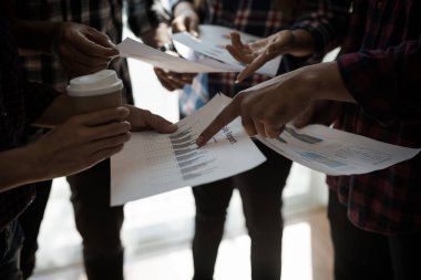 Ekose gömlekli bir kadın ve erkek çalışan bir grup insan iş yapma hakkında konuşuyor / danışmanlık yapıyor. Takım çalışması iş toplantısı