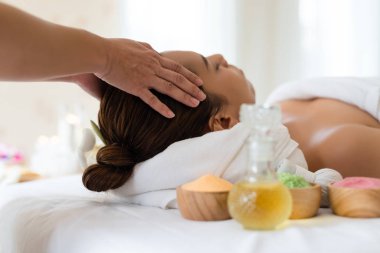 Güzel Asyalı kız güzellik salonunda yüz masajı yaptırıyor.