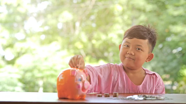 Ασίας Αγόρι Ένα Χαρούμενο Χαμόγελο Διασκεδαστικό Βάζοντας Κέρματα Έναν Κουμπαρά — Φωτογραφία Αρχείου