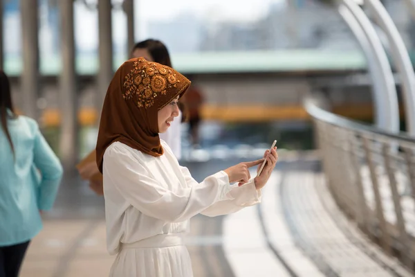 Portrait of young malaysia woman touching on cellphone contact.