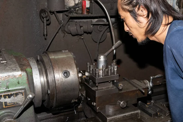 Torna tezgahında çalışan bir adam koruyucu giysi giymez. İş için güvenli değil.