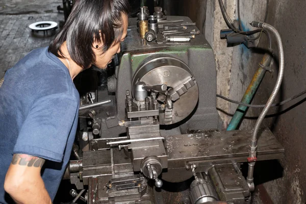 Torna tezgahında çalışan bir adam koruyucu giysi giymez. İş için güvenli değil.