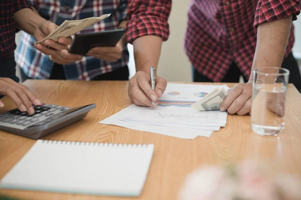 Grup işadamı ve kadın hesap makinesi kullanıyor. İş payını hesaplamış.