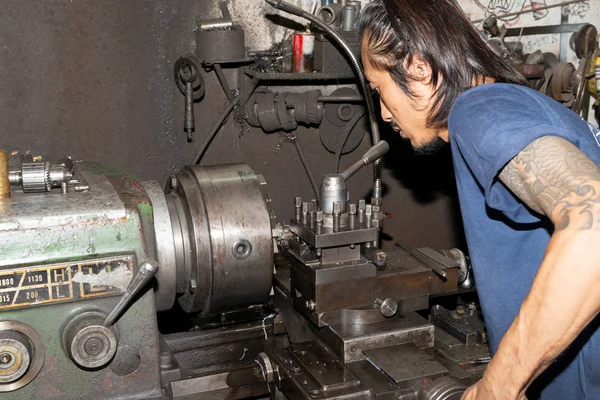 Torna tezgahında çalışan bir adam koruyucu giysi giymez. İş için güvenli değil.