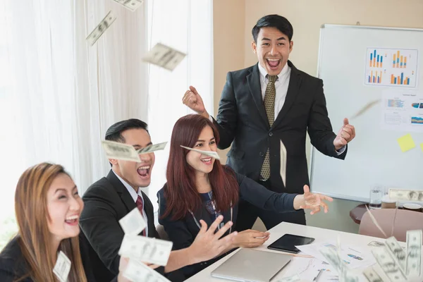 Asyalı iş adamı ve kadın grupları, başarılı iş. Burada çok para var. Ofis masasında bir dizüstü bilgisayar ve belgeyle. iş başarısı konsepti