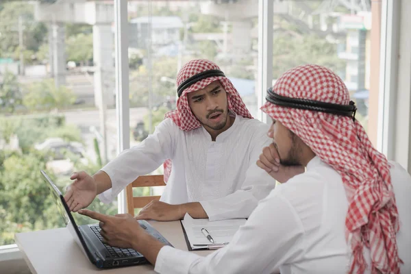 İki iş adamı bir dizüstü bilgisayarla çalışıyor. İş analizi yapıyorlar, tartışıyorlar. Beyin fırtınası, takım çalışması, toplantı konsepti.