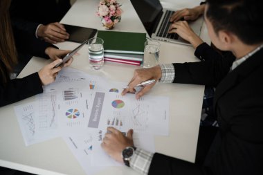 Asyalı iş adamlarından oluşan bir grup iş raporu, satış, pazarlama, konsept hakkında konuşuyor. Dijital tablet ve dizüstü bilgisayar üzerinde çalışırken ofisteki konferans odasında tartışıyor.