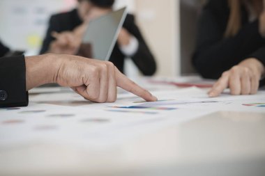 İşadamlarının eli grafiği gösteriyor. Grup ofis masasında borsa tabloları üzerinde tartışırken, onlar iş analizi yapıyorlar. Beyin fırtınası, takım çalışması, toplantı konsepti.