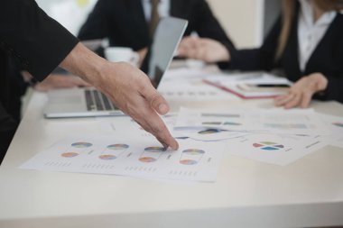 İşadamlarının eli grafiği gösteriyor. Grup ofis masasında borsa tabloları üzerinde tartışırken, onlar iş analizi yapıyorlar. Beyin fırtınası, takım çalışması, toplantı konsepti.