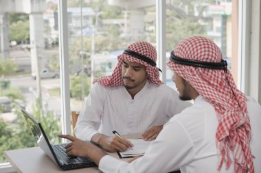 İki iş adamı bir dizüstü bilgisayarla çalışıyor. İş analizi yapıyorlar, tartışıyorlar. Beyin fırtınası, takım çalışması, toplantı konsepti.
