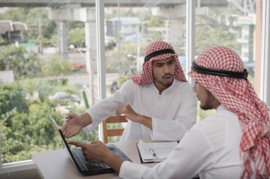 İki iş adamı bir dizüstü bilgisayarla çalışıyor. İş analizi yapıyorlar, tartışıyorlar. Beyin fırtınası, takım çalışması, toplantı konsepti.