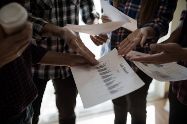 Ekose gömlekli bir kadın ve erkek çalışan bir grup insan iş yapma hakkında konuşuyor / danışmanlık yapıyor. Takım çalışması iş toplantısı