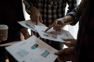 Ekose gömlekli bir kadın ve erkek çalışan bir grup insan iş yapma hakkında konuşuyor / danışmanlık yapıyor. Takım çalışması iş toplantısı