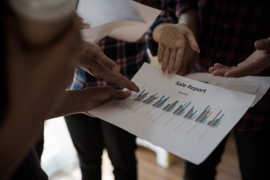 Ekose gömlekli bir kadın ve erkek çalışan bir grup insan iş yapma hakkında konuşuyor / danışmanlık yapıyor. Takım çalışması iş toplantısı