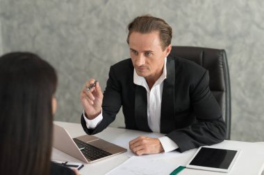 Kızgın kaba patron bağırarak kölelerin işini şikayet ediyor. Sunulan rapordan memnun değildi..