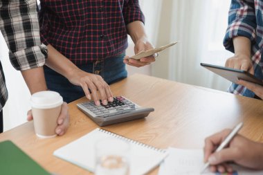 Grup işadamı ve kadın hesap makinesi kullanıyor. İş payını hesaplamış.