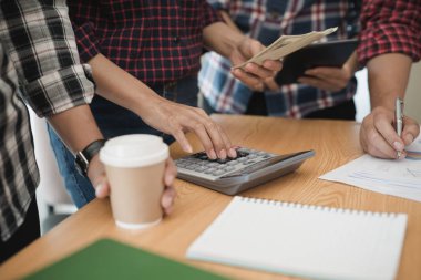 Grup işadamı ve kadın hesap makinesi kullanıyor. İş payını hesaplamış.